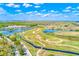 Scenic aerial view of a golf course with lush greenery and blue water features under a partly cloudy sky at 518 Cortez Dr, Davenport, FL 33837