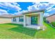 Backyard with covered patio, green lawn, and partial view of the rear exterior of the home at 518 Cortez Dr, Davenport, FL 33837