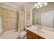 Bathroom featuring a vanity with sink, neutral tile walls, framed mirror, and a shower-tub combination at 518 Cortez Dr, Davenport, FL 33837