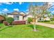 Charming single-Gathering home featuring lush landscaping, a tree, and a brick driveway at 518 Cortez Dr, Davenport, FL 33837