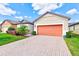 Single-Gathering house with an orange two-car garage and well-manicured landscaping at 518 Cortez Dr, Davenport, FL 33837