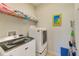 Efficient laundry room featuring a modern washer and dryer set, with a shelf for storage above at 518 Cortez Dr, Davenport, FL 33837