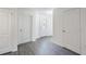Bright hallway with gray wood-look floors, white walls, and stylish interior doors at 567 Bay Leaf Dr, Poinciana, FL 34759