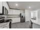 A bright kitchen features white cabinets, stainless steel appliances, and stylish gray wood-look flooring at 567 Bay Leaf Dr, Poinciana, FL 34759