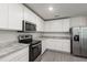 Well-lit kitchen featuring gray wood-look floors, stainless appliances, and granite countertops at 567 Bay Leaf Dr, Poinciana, FL 34759