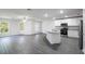 Open-concept room featuring a modern kitchen area and living space with gray wood-look flooring at 567 Bay Leaf Dr, Poinciana, FL 34759