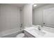 Bright bathroom featuring a tub, modern sink, and white tile at 576 Bay Leaf Dr, Poinciana, FL 34759
