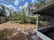 Backyard featuring lush greenery and partial view of screened-in patio at 606 El Vedado Ave, Orlando, FL 32807