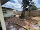 Backyard featuring a mature tree, wooden fence, and partial view of the home's exterior at 606 El Vedado Ave, Orlando, FL 32807