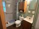 A compact bathroom featuring a shower, vanity, toilet, and wooden storage cabinet at 606 El Vedado Ave, Orlando, FL 32807
