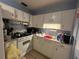 A full kitchen with white cabinets, tiled floors and standard appliances at 606 El Vedado Ave, Orlando, FL 32807