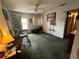 A living room with green carpet, a ceiling fan, a side table, and a door leading outside at 606 El Vedado Ave, Orlando, FL 32807