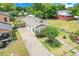 An aerial view showcasing a long driveway, mature trees, and the home's proximity to nearby residences at 830 Polk St, Orlando, FL 32805