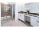 Elegant bathroom with a double vanity, gray countertops, and a glass-enclosed shower at 3008 Protagonist St, Kissimmee, FL 34746