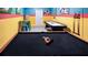 Game room with pool table and air hockey table, featuring vibrant, playful decor at 3008 Protagonist St, Kissimmee, FL 34746