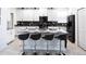 Contemporary kitchen with white cabinets, a black subway tile backsplash, and seating at the center island at 3008 Protagonist St, Kissimmee, FL 34746