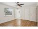 Bright bedroom with hardwood floors, a ceiling fan, and a window with blinds, offering a serene and comfortable space at 520 Hamlet Dr, Port Orange, FL 32127