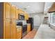 Functional kitchen with wooden cabinets, tiled countertops, and stainless steel appliances at 520 Hamlet Dr, Port Orange, FL 32127
