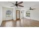Bright living room featuring unique arched windows, wood-look tile floors, textured walls, and ceiling fans at 520 Hamlet Dr, Port Orange, FL 32127