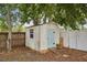 Backyard shed with a blue door next to a wood fence amongst the trees at 520 Hamlet Dr, Port Orange, FL 32127