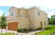 Two-story home with manicured front yard, featuring a two-car garage and lush landscaping at 600 Bay Leaf Dr, Poinciana, FL 34759