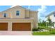 Charming two-story home with a two-car garage, well-manicured lawn, and beautiful landscaping at 600 Bay Leaf Dr, Poinciana, FL 34759