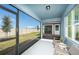 Relaxing screened patio with chairs offering views of the backyard and clear blue skies at 6780 Sw 90Th Loop, Ocala, FL 34476
