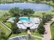 Aerial view of a community pool and clubhouse surrounded by lush landscaping and a serene lake at 14563 Bahama Swallow Blvd, Winter Garden, FL 34787