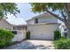 Exterior home featuring two-car garage, white fencing, and lush greenery at 14563 Bahama Swallow Blvd, Winter Garden, FL 34787