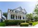 Charming two-story white house with a welcoming front porch, beautifully landscaped yard, and lush green bushes at 14563 Bahama Swallow Blvd, Winter Garden, FL 34787
