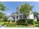 Beautiful home with a classic white exterior, a charming porch, and lush landscaping, offering curb appeal and tranquility at 14563 Bahama Swallow Blvd, Winter Garden, FL 34787