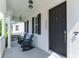 Cozy front porch featuring rocking chairs, a stylish entrance door, and classic architectural details, perfect for relaxation at 14563 Bahama Swallow Blvd, Winter Garden, FL 34787