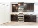 Close up on kitchen features dark wood cabinetry, stainless steel microwave and double oven, and granite counters at 14563 Bahama Swallow Blvd, Winter Garden, FL 34787