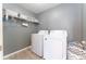 Functional laundry room with a washer, dryer, and overhead shelving for storage and organization at 14563 Bahama Swallow Blvd, Winter Garden, FL 34787