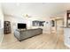 Bright living room with light wood floors, gray sofa, ceiling fan, and view to dining area at 14563 Bahama Swallow Blvd, Winter Garden, FL 34787