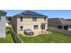 Two-story home with solar panels and backyard featuring a private hot tub and red brick patio at 159 Lazy Willow Dr, Davenport, FL 33897