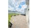 Paver patio with a hot tub and potted plants, surrounded by a white vinyl fence at 159 Lazy Willow Dr, Davenport, FL 33897