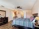 Well-lit primary bedroom featuring dark wood floors, a ceiling fan and lots of windows at 159 Lazy Willow Dr, Davenport, FL 33897
