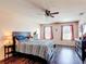 Comfortable bedroom featuring wood floors, a ceiling fan and a cat tree next to the window at 159 Lazy Willow Dr, Davenport, FL 33897