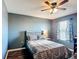 Cozy bedroom featuring a ceiling fan, wood-look floors, and a window at 159 Lazy Willow Dr, Davenport, FL 33897