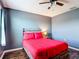 Modern bedroom with a red comforter, wood-look floors, and neutral gray paint at 159 Lazy Willow Dr, Davenport, FL 33897