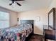 Bedroom featuring a queen bed, floral linens, wood-look floors, and a window with blinds at 159 Lazy Willow Dr, Davenport, FL 33897