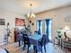 Well-lit dining room with a wooden table, chandelier and large windows with blue curtains at 159 Lazy Willow Dr, Davenport, FL 33897