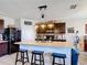 Spacious kitchen island featuring dark cabinets, seating for three, neutral countertops and stainless steel appliances at 159 Lazy Willow Dr, Davenport, FL 33897