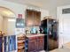 Kitchen featuring dark cabinets, a mosaic backsplash, and modern appliances for convenience at 159 Lazy Willow Dr, Davenport, FL 33897