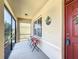 Inviting screened porch with chairs and a welcome sign, perfect for relaxing outdoors at 159 Lazy Willow Dr, Davenport, FL 33897