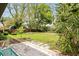 Lush backyard with mature trees, ample green space, and a patio area for outdoor entertaining at 2013 Pineway Dr, Orlando, FL 32839