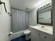Bathroom with vanity and white cabinets, blue tiled floor, and a silver-framed mirror at 568 Bahia Cir # B, Ocala, FL 34472