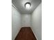 A hallway with wood floors leads to a white front door with a bulb ceiling light at 568 Bahia Cir # B, Ocala, FL 34472