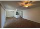 A spacious living room featuring a ceiling fan, carpeted floors, and an open view to the kitchen at 568 Bahia Cir # B, Ocala, FL 34472
